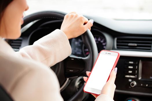Closeup shot of female driver holding a smartphone or navigation device