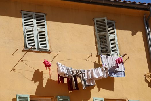 Drying Laundry Clothes Hanging Outside The Window of an Old Building in the Historic Center of Menton, France / French Riviera