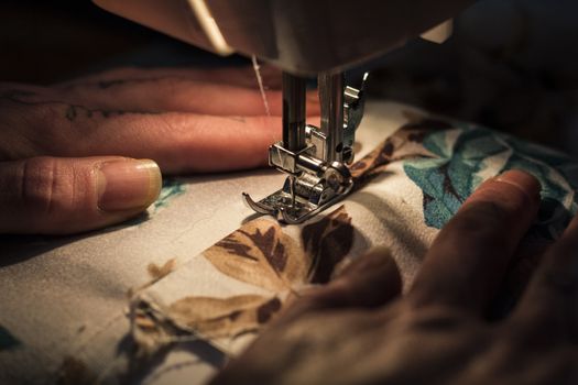 Tailor at Work on Sewing Machine with human hand