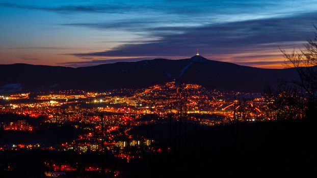 Evening view of illuminated Liberec city and Jested Mountain. Night scene.