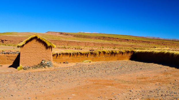 Landscape of southern Altiplano with clay brick wall and small hut, Andes, Bolivia.