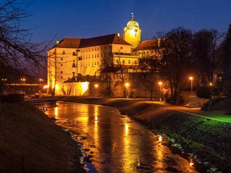 Illuminated Podebrady Castle at Labe River by night, Czech Republic.