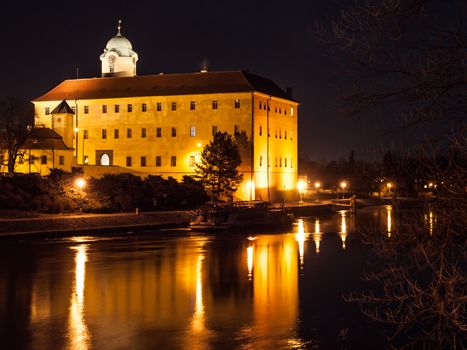 Illuminated Podebrady Castle at Labe River by night, Czech Republic.