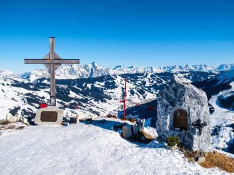 Summit cross on Zwolferkogel. Alpine winter ski resort Saalbach Hinterglemm, Austrian Alps.