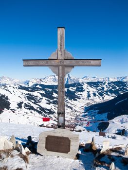 Summit cross on Zwolferkogel. Alpine winter ski resort Saalbach Hinterglemm, Austrian Alps.