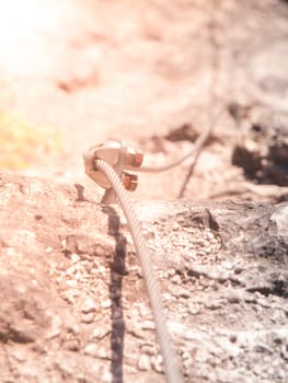 Close-up view of bolt via ferrata cable fastening. Outdoor rock climbing equipment.