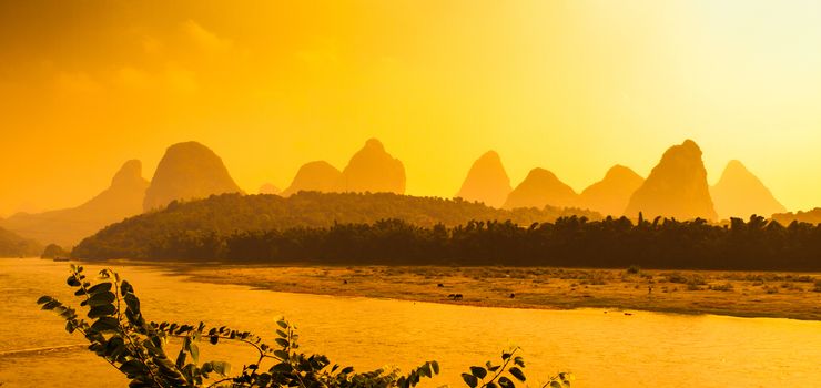 Sunset panorama in karst landscape around Yangshuo an Li River with peaks silhouettes, Guangxi Province, China.