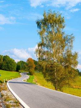 Winding asphalt road in rural landscape of Sumava Mountains, Czech Republic.