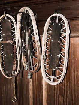 Vintage wooden snowshoes hanging on the wall in mountain cottage.
