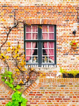 Picturesque window of an old brick house, Bruges, Belgium.