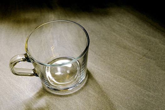 Transparent mug on a marble background early in the morning