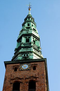 Spire of St. Nicholas Church against Blue Sky Outdoors Bottom View. Copenhagen, Denmark