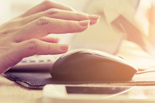 Close-up of female hands using laptop computer, working on laptop with flare light background. Searching Internet ,Businesswoman working at home office