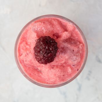 Blackberry smoothie on a white concrete background. Square cropping
