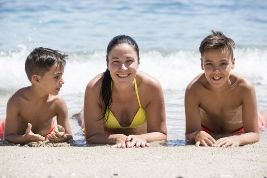 Family mother and her sons on the beach