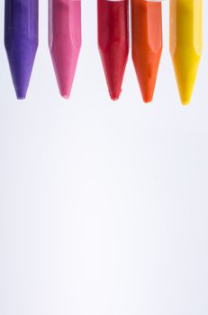 Crayons of various color on white background