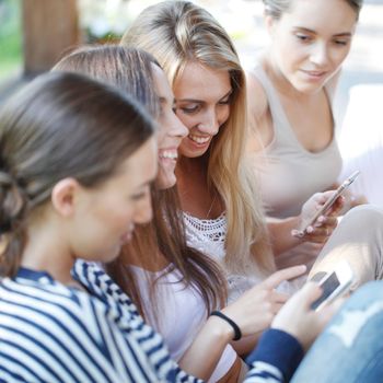 Portrait of girls chatting with their smartphones outdoors