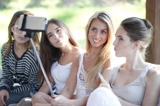 Young beautiful female friends taking selfie outdoors