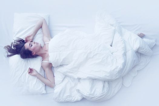 Young girl sleeping in bed, top view