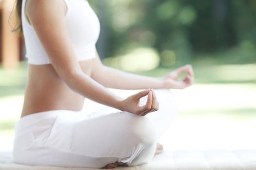 Close-up of young woman doing yoga exercise in the park