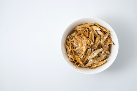 fried small fish in a cup on white background