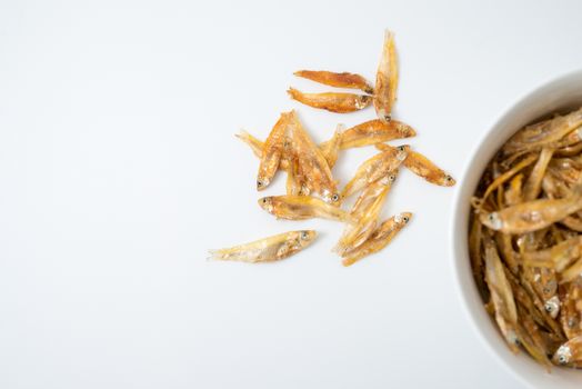 fried small fish in a cup on white background