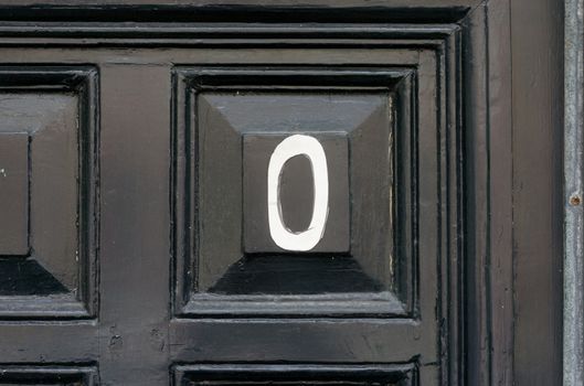 house number zero painted on a door panel