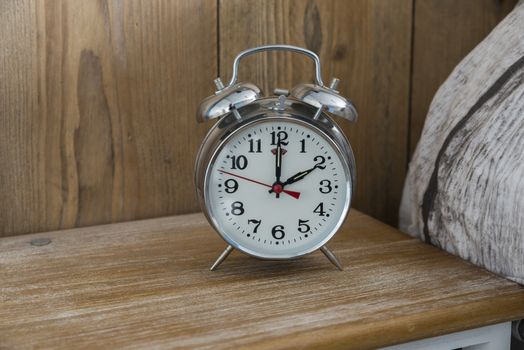 An old fashioned silver coloured bed side analogue pre digital alarm clock