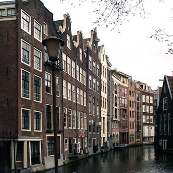 Typical water canal - gracht - and narrow houses along it in Amsterdam city centre, Netherlands