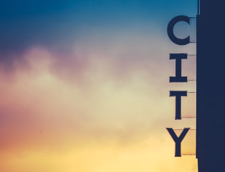 A Silhouette Of A City Sign On The Side Of A Building At Sunset With Copy Space