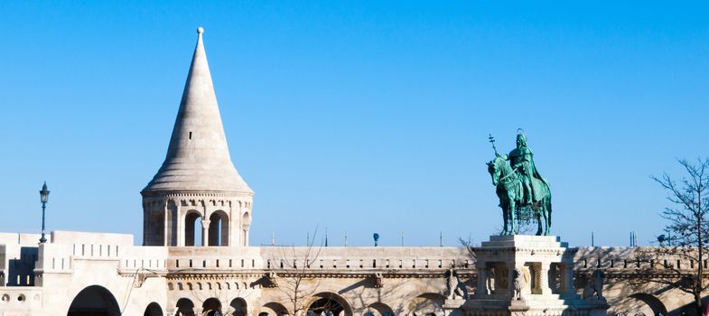 Mounted statue of Saint Stephen I, aka Szent Istvan kiraly - the first king of Hungary at typical white rounded tower of Fisherman's Bastion in Buda Castle in Budapest, Hungary, Europe. Sunny day shot with blue sky on the background.
