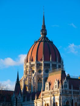 Detailed view of historical building of Hungarian Parliament, aka Orszaghaz, with typical central dome on clear blue sky background. Budapest, Hungary, Europe. It is notable landmark and seat of the National Assembly of Hungary. UNESCO World Heritage Site.