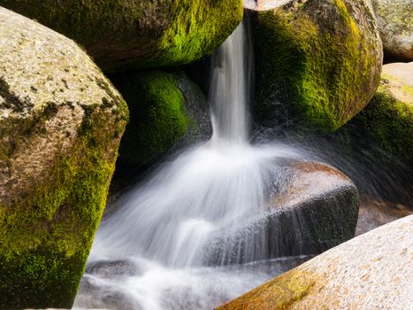 Blurred river stream detail of wild rocky mountain river. Silky effect. Motion rendition effect. Slow shutter speed effect. Long exposure effect.