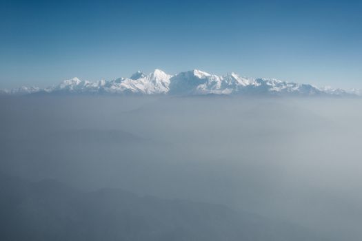 The Himalayas as seen from an airplane in Nepal. Layer of clouds beneath the mountain tops.