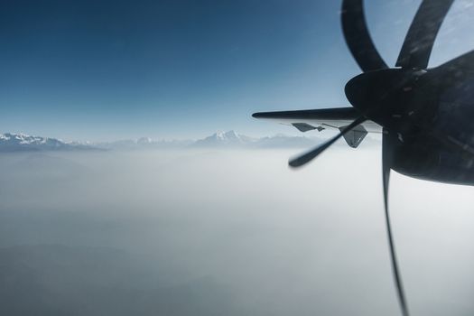 The Himalayas as seen from a propeller plane in Nepal. Layer of clouds beneath the mountain tops.