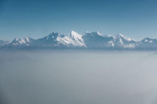 The Himalayas as seen from an airplane in Nepal. Layer of clouds beneath the mountain tops.