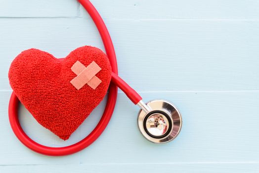 World health day, Healthcare and medical concept. Red heart with Stethoscope, notepad or notebook, thermometer and yellow Pill on Pastel white and blue wooden table background texture.