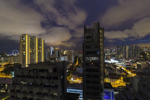 Singapore cityscape with rooftop view of apartment buildings with dramatic cloudy night sky