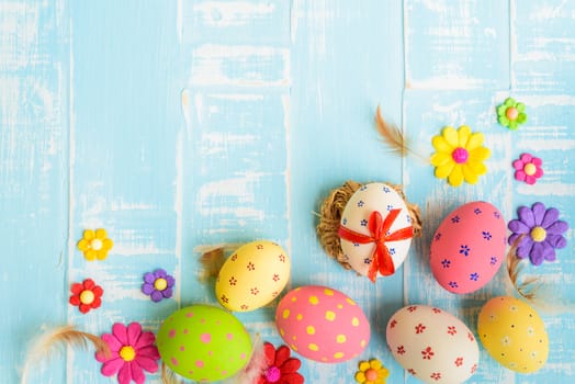 Happy easter! Colorful of Easter eggs in nest on pastel color bright green and white wooden background.