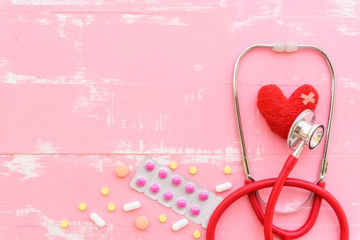 World health day, Healthcare and medical concept. Red heart with Stethoscope, notepad or notebook, thermometer and yellow Pill on Pastel white and blue wooden table background texture.