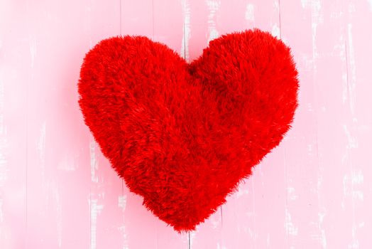 Beautiful big red pillow heart shape on white and pink wooden background. Love, Wedding and Valentines day concept.