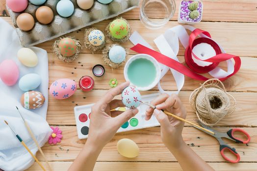 Happy easter! A woman hand painting Easter eggs. Happy family preparing for Easter.