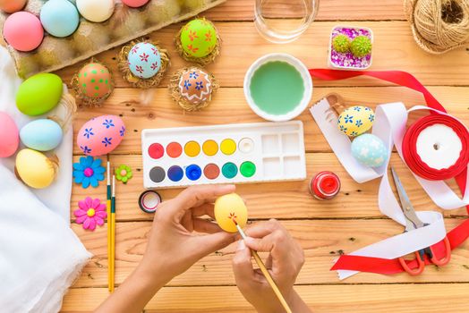 Happy easter! A woman hand painting Easter eggs. Happy family preparing for Easter.