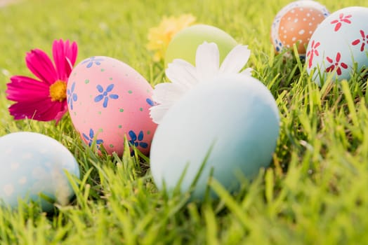 Happy easter!  Closeup Colorful Easter eggs on green grass field during sunset background.