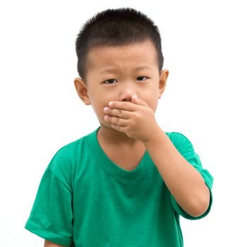 Asian child covering his mouth with hand. Portrait of young boy isolated on white background.