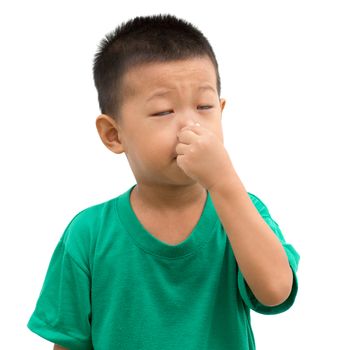 Asian child pinching nose with hands. Portrait of young boy isolated on white background.