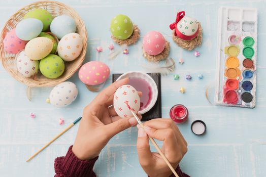 Happy easter! A woman hand painting Easter eggs. Happy family preparing for Easter.