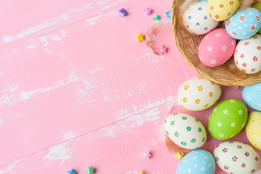 Happy easter! Colorful of Easter eggs in nest with paper star, flower and Feather on pastel color bright pink and white wooden background.