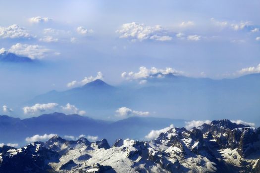 snow-caped mountain peaks and clouds in the distance