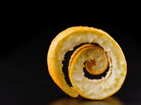 twist of citrus peel on a black background